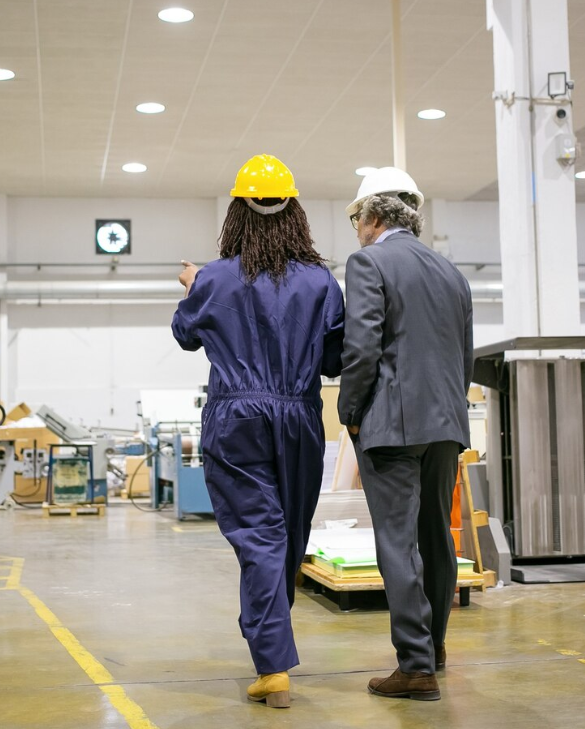 Consultant en visite d’usine aux côtés d’un ingénieur pour un audit industriel.